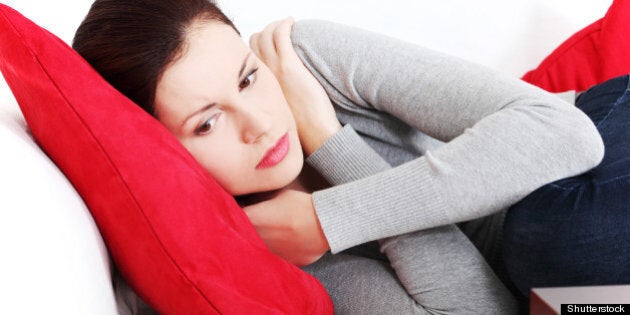 stressed woman lying on sofa at ...