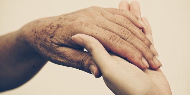 Young female hand holding old female hand - Taking care of the elderly people with love