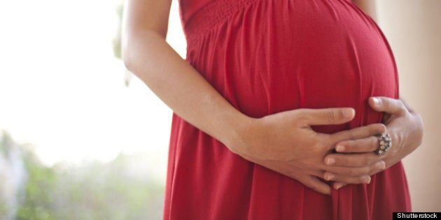 Image of pregnant woman touching her belly with hands