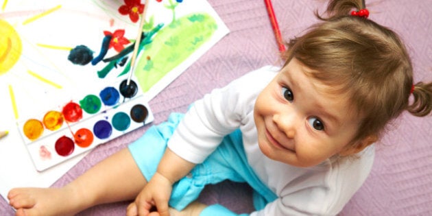 Little cute girl painting sun inside