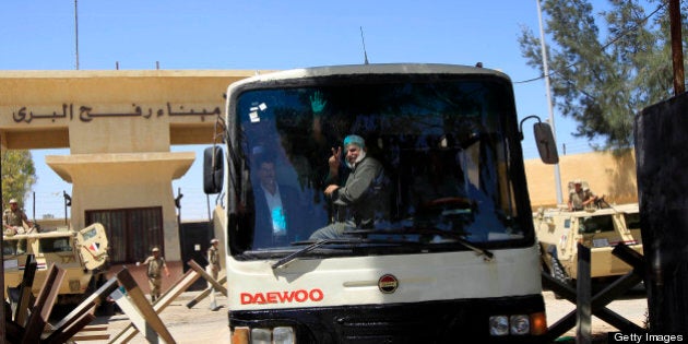 Palestinian men gesture from inside a bus as they cross back into the southern Gaza Strip through the Rafah border terminal with Egypt, on May 22, 2013. The Rafah border crossing between Egypt and the Gaza Strip reopened today, five days after its closure by Egyptian police angered by the kidnapping of seven colleagues, witnesses said. AFP PHOTO/ SAID KHATIB (Photo credit should read SAID KHATIB/AFP/Getty Images)