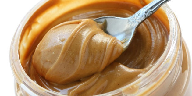 an open jar of peanut butter with spoon