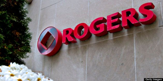 The Rogers logo sits on display outside the company's headquarters building in Toronto, Ontario, Canada, on Tuesday, Oct. 26, 2010. Rogers Communications Inc., Canada's largest wireless carrier, said third-quarter profit declined 24 percent as it added fewer subscribers and spent more on current customers' phone upgrades. The stock slumped as net income dropped to C$370 million. Photographer: Norm Betts/Bloomberg via Getty Images