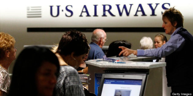 PHOENIX, AZ - APRIL 19: Travelers check-in at the US Airways ticket counter at Sky Harbor International Airport on April 19, 2012 in Phoenix, Arizona. As American Airlines continues through bankruptcy US Airways is working on a possible deal to takeover the troubled airline. (Photo by Joshua Lott/Getty Images)