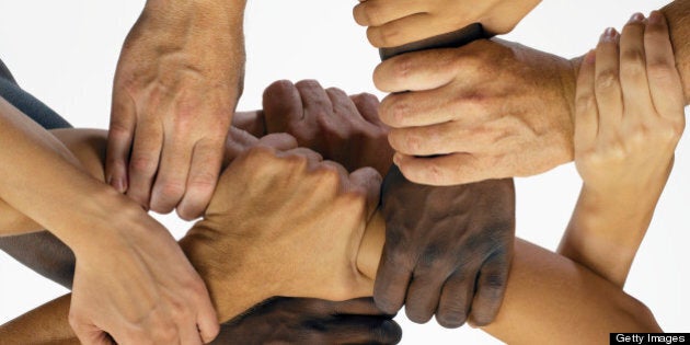 Men and women interlocking hands, close-up, overhead view