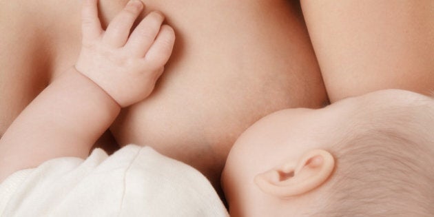 mother breast feeding her...
