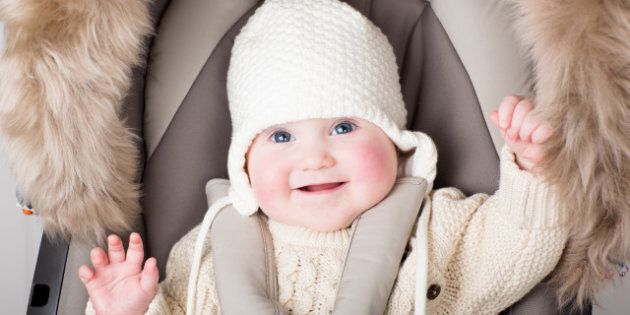 funny little baby in a warm hat ...
