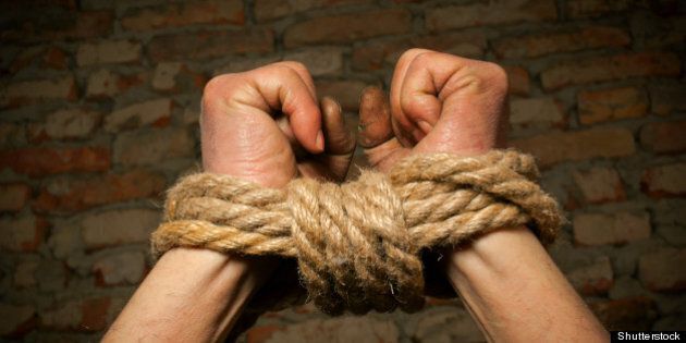 hands of man tied up with rope...