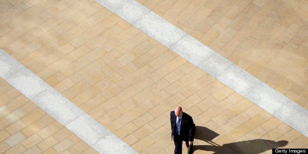 A businessman walks away from the London Stock Exchange and across Paternoster Square in London, U.K., on Tuesday, April 23, 2013. The pound rose for a third day against the euro before an industry report that economists said will show U.K. retail sales increased and amid speculation the Bank of England's loan-program extension will boost the economy. Photographer: Simon Dawson/Bloomberg via Getty Images