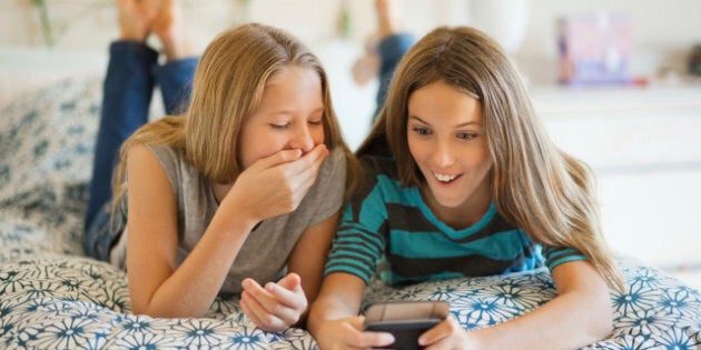 Surprised siblings looking at cell phone while lying on bedhttp://i449.photobucket.com/albums/qq220/iphotoinc/KidsBanner.jpg