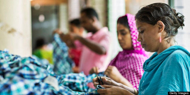 A worker cuts the thread on a plaid shirt on the production line of the Fashion Enterprise garment factory in Dhaka, Bangladesh, on Monday, April 29, 2013. Bangladesh authorities said they were accelerating rescue efforts at the factory complex that collapsed last week as hopes fade for more survivors after the nation's biggest industrial disaster. The government has decided to constitute a panel to identify garment factories in the country at risk of collapse, cabinet secretary Hossain Bhuiyan told reporters on April 29. Photographer: Jeff Holt/Bloomberg via Getty Images