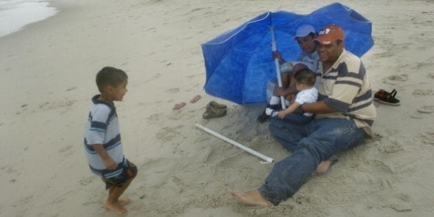 With Tropical Storm Gabrielle looming offshore, Jose and Minerva Perez tried to squeeze in a few extra minutes at the beach with their children Manuel, 3, left, and Raul, 6 months, Sunday, September 9, 2007 in Atlantic Beach, North Carolina. The weak tropical storm landed at the Outer Banks with 50mph winds. (Photo by Jason Arthurs/Raleigh News & Observer/MCT via Getty Images)