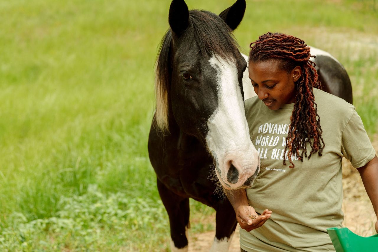 Keisha feeds her horse, Hercules, who helped inspire her to create the farm.
