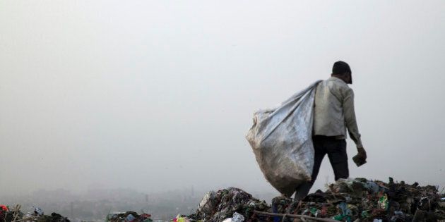A rag picker carries a sack of sorted recyclable materials collected from garbage at the Ghazipur landfill site in the east of New Delhi, India, on Friday, May 30, 2014. New Delhi, whose population will reach almost 21 million by 2015, generates 8,000 tons of garbage a day. Trash is not separated between organic and inorganic materials -- everything from leftover food to batteries and beverage cans goes into Indian bins -- hurting efficiency and raising toxic emissions. Photographer: Udit Kulshrestha/Bloomberg via Getty Images