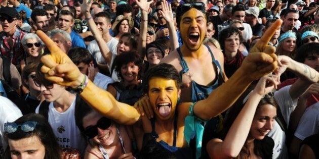 Festival-goers react during a concert of the band Detroit on July 19, 2014, during the 23rd edition of the Festival des Vieilles Charrues in Carhaix-Plouguer, western France. AFP PHOTO / FRED TANNEAU (Photo credit should read FRED TANNEAU/AFP/Getty Images)