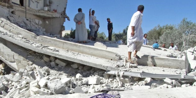 Men gather on the remains of a destroyed building after reported air strikes by Syrian government forces in the rebel-held northwestern Syrian province of Idlib on September 5, 2013. The Syrian Observatory for Human Rights watchdog said Syrian war planes bombed rebel held areas in Idlib, Aleppo, Hama and Lattakia. AFP PHOTO / ABU AMAR AL-TAFTANAZ (Photo credit should read ABU AMAR AL-TAFTANAZ/AFP/Getty Images)