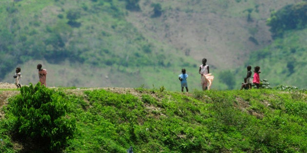 Haitian children stand on a ridge alongside the road known as La Internacional that divides Hispaniola island into the Dominican Republic to the east, and Haiti to the west, in Guayajayuco, May 13, 2012. The border of the two countries that share an island but have historically tense relations that have included wars and massacres, is 388 km (241 miles) long and bisects a region of deep poverty where the trade imbalance favors the Dominican Republic by more than 100 to 1, according to official estimates. Despite their cultural differences many Haitians have migrated across the border seeking jobs, swelling the Haitian population in the Dominican Republic to over 800,000, almost ten percent of the Dominican total. Picture taken May 13, 2012. REUTERS/Ricardo Rojas (DOMINICAN REPUBLIC - Tags: POLITICS ENVIRONMENT SOCIETY)