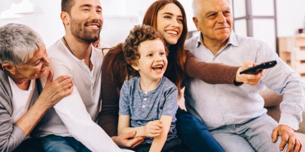 A three generation family switching the channels on the TV.