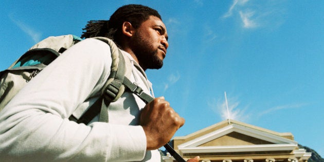 Low angle view of a young man carrying a shoulder bag