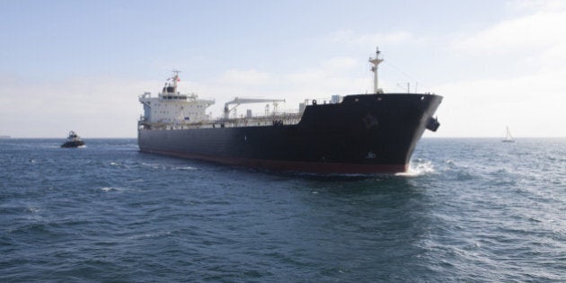 Oil tanker with tugboat at sea