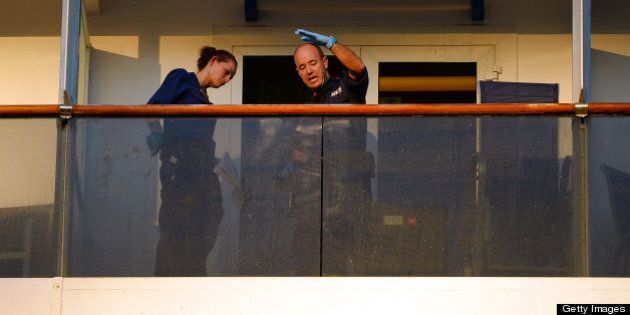 Two police officers check for fingerprints on the balcony of the cabin of two passengers who fell overboard from the cuise ship Carnival Spirit as it returned to Sydney from a Pacific cruise, on May 9, 2013. A search was underway off Australia for the couple in shark-infested waters and after reviewing security footage on the ship, police said they believe the pair fell overboard just before 9pm on Wednesday (1100 GMT Wednesday) around 65 nautical miles off the coast, north of Sydney. AFP PHOTO / William WEST (Photo credit should read WILLIAM WEST/AFP/Getty Images)