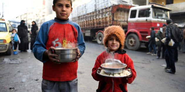 Children carry cooked meals provided by the UN through a partner NGO at al-Mashatiyeh neighborhood of east Aleppo, Syria, in this handout picture provided by UNHCR on January 4, 2017. Bassam Diab/UNHCR/Handout via Reuters REUTERS ATTENTION EDITORS - THIS PICTURE WAS PROVIDED BY A THIRD PARTY. REUTERS IS UNABLE TO INDEPENDENTLY VERIFY THE AUTHENTICITY, CONTENT, LOCATION OR DATE OF THIS IMAGE. FOR EDITORIAL USE ONLY.