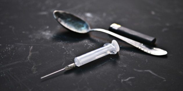 studio photography of syringe, spoon and lighter on black background