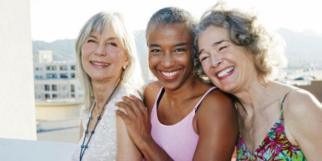 Women smiling together on urban rooftop