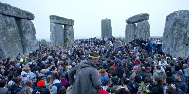 Revelllers celebrate the pagan festival of 'Summer Solstice' at Stonehenge in Wiltshire in southern England, on June 21, 2013. The festival, which dates back thousands of years, celebrates the longest day of the year when the sun is at its maximum elevation. Modern druids and people gather at the landmark Stonehenge every year to see the sun rise on the first morning of summer. AFP PHOTO / JUSTIN TALLIS (Photo credit should read JUSTIN TALLIS/AFP/Getty Images)