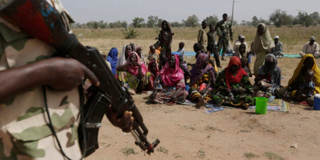 FILE- In this Tuesday, Dec. 8, 2015 file photo, soldiers guard people fleeing from Boko Haramâs carnage and about to be searched to ensure there are no insurgents infiltrating a refugee camp. People detained by the military and a civilian self-defense force are disappearing in northeast Nigeria, some wrongly accused of fighting for Boko Haram by neighbors settling old scores. The army says it is setting up a human rights office to investigate complaints. Amnesty International holds Nigeriaâs military responsible for the deaths of some 8,000 detainees since 2011 _ more than a third of the 20,000 people who have died in Nigeriaâs Islamic uprising. (AP Photo/Sunday Alamba, file)