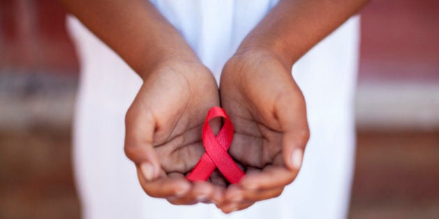 Child's hands holding an HIV awareness ribbon, Cape Town, South Africa