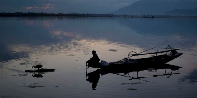 A Kashmiri fisherman prepares to bring to shore his Shikara, or traditional boat, after a days work at the Dal Lake on the outskirts of Srinagar, Indian controlled Kashmir, Wednesday, April 8, 2015. Nestled in the Himalayan mountains and known for its beautiful lakes and saucer-shaped valleys, the Indian portion of Kashmir, is also one of the most militarized places on earth.(AP Photo/Dar Yasin)