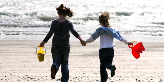 Jaquline Reeder, 8 (left) and Rosie Reeder, 7, carry buckets and spades along the beach at Looe, Cornwall, where holiday makers are enjoying the warm sunshine.