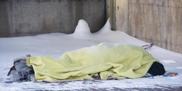 A homeless person sleeps on a snow covered sidewalk on December 23, 2008 in Montreal, Quebec, Canada. A week after a homeless man was found dead in Park Viger, other homeless people were still sleeping outdoors in very cold conditions. Temperatures plunged in Canada below freezing, with the central province of Saskatchewan reporting four below zero degrees Fahrenheit (negative 38 Celsius) Monday morning, and further east around 20 centimeters (eight inches) of snow covered Montreal. AFP PHOTO/ ROGERIO BARBOSA (Photo credit should read ROGERIO BARBOSA/AFP/Getty Images)