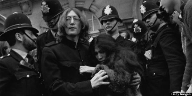 19th October 1968: Beatles singer, songwriter and guitarist John Lennon (1940 - 1980) and his partner artist Yoko Ono, leaving court surrounded by police. (Photo by Evening Standard/Getty Images)