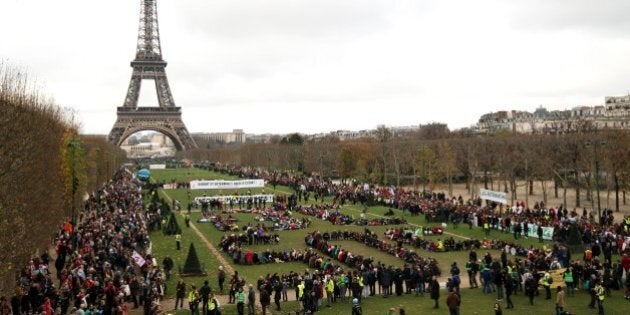 TOPSHOT - Several Non Governmental Organisations (NGO) gather to form a human chain reading '+3°C SOS' on the Champs de Mars near the Eiffel Tower on December 12, 2015 in Paris on the sidelines of the COP21, the UN conference on global warming.French hosts submit the final version of a global climate-saving pact to negotiators at UN Conference on december 12. The goal is for ministers to approve the agreement by the end of the day but that could be extended one more day. / AFP / ALAIN JOCARD (Photo credit should read ALAIN JOCARD/AFP/Getty Images)
