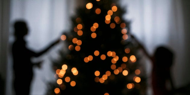 Silhouette of mother and daughter decorating a Christmas tree