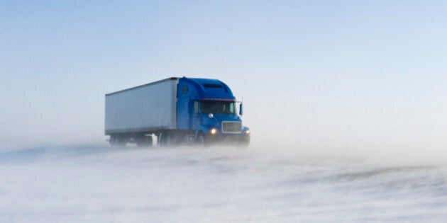 Truck on road covered with blowing snow, near Morris, Manitoba, Canada