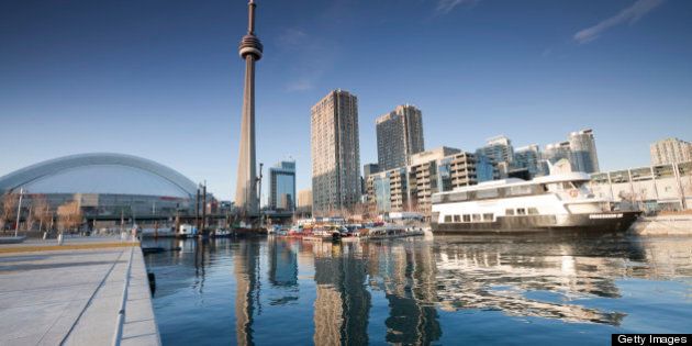 Reflection of a cruise ship, the CN Tower, the Radisson Hotel and other buildings along Harbourfront at Queen's Quay in downtown Toronto, Ontario
