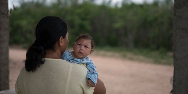 Josiane da Silva holds her son Jose Elton, who was born with microcephaly, outside her house in Alcantil, Paraiba state, Brazil, Sunday, Feb. 7, 2016. The Zika virus, spread by the Aedes aegypti mosquito, thrives in people's homes and can breed in even a bottle cap's-worth of stagnant water. Public health experts agree that the poor are more vulnerable because they often lack amenities that help diminish the risk. (AP Photo/Felipe Dana)