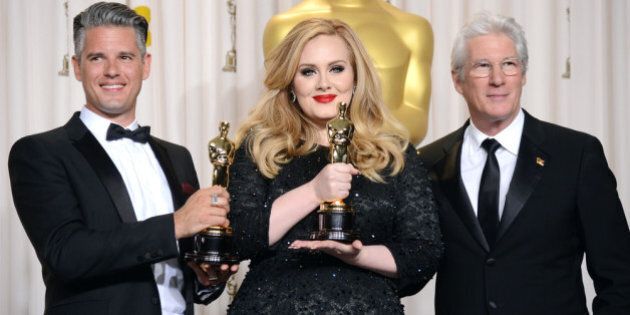HOLLYWOOD, CA - FEBRUARY 24: (L-R) Songwriter Paul Epworth and singer Adele, winners of the Best Original Song award for 'Skyfall,' with presenter Richard Gere pose in the press room during the Oscars held at Loews Hollywood Hotel on February 24, 2013 in Hollywood, California. (Photo by Jason Merritt/Getty Images)