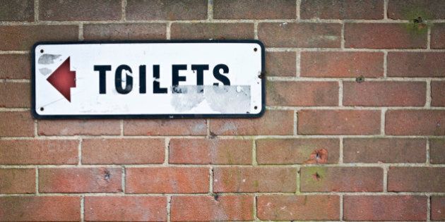 TOILETS SIGN ON BRICK WALL