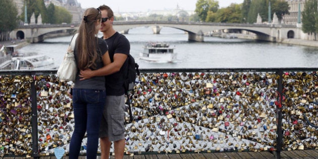 TO GO WITH AFP STORY BY BONIFACE MURUTAMPUNZIA couple kisses at the Pont des Arts where padlocks are attached to the railing, on August 30, 2013 in Paris. Due to security reason authorities consider removing the 'Love locks' that have been attached to the Pont des Arts bridge since 2008 by thousand of lovers.AFP PHOTO / PATRICK KOVARIK (Photo credit should read PATRICK KOVARIK/AFP/Getty Images)