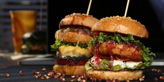 Huge Double hamburger with fresh grilled beef isolated on a black background with pistachios