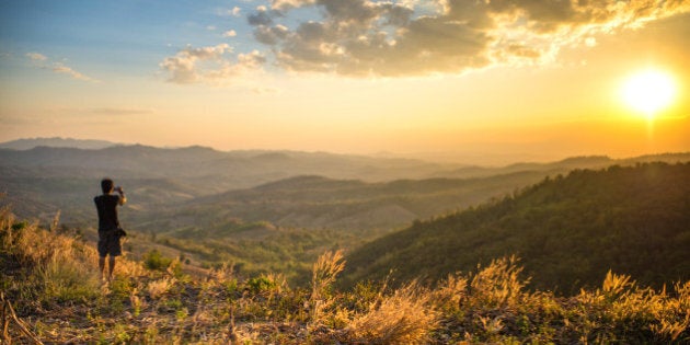 Tourist standing on the hill and take a photo in the beautiful sunset time and good landscape area, Loei province, Thailand