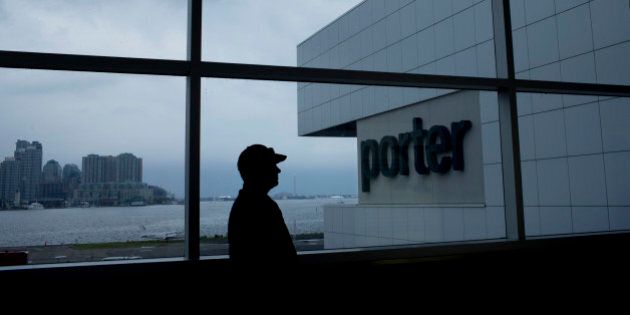 The silhouette of a traveler is seen standing near Porter Airlines Inc. signage at Billy Bishop Toronto City Airport in Toronto, Ontario, Canada, on Friday, June 28, 2013. Porter Airlines Inc., the Canadian carrier that now flies only turboprops, plans to add its first jets to start long-haul flights in an expanded challenge to Air Canada and WestJet Airlines Ltd. Photographer: Brent Lewin/Bloomberg via Getty Images