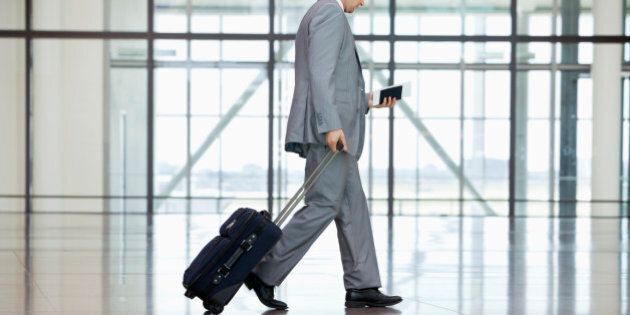 Low section of businessman walking at airport
