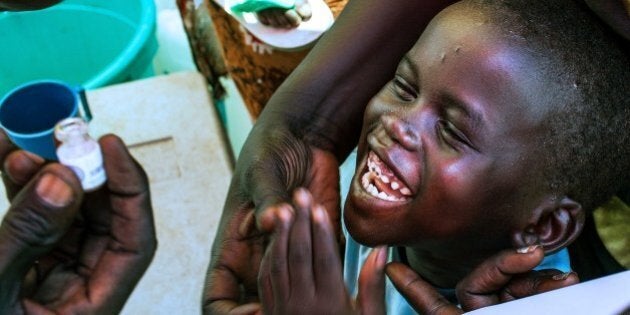 A child smiles as he prepares to receive a dose of oral cholera vaccine inside a tent of the United Nation Mission in South Sudan (UNMISS), at their Tongping base in the South Sudan capital, Juba, on March 1, 2014. Limited water supplies, poor sanitary conditions and a high level of congestion led to a mass oral cholera vaccination campaign. AFP PHOTO / ANDREI PUNGOVSCHI (Photo credit should read ANDREI PUNGOVSCHI/AFP/Getty Images)