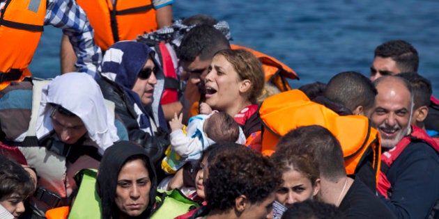 Syrian refugees arrive aboard a dinghy after crossing from Turkey, to the island of Lesbos, Greece, on Sunday, Sept. 20, 2015. A boat with 46 people fleeing Syria sank Sunday in Greece and the coast guard said it is searching for more than 20 others missing off the eastern Aegean island of Lesbos. (AP Photo/Petros Giannakouris)