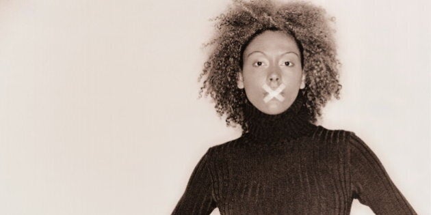 Young woman with tape over mouth, portrait (toned B&W)